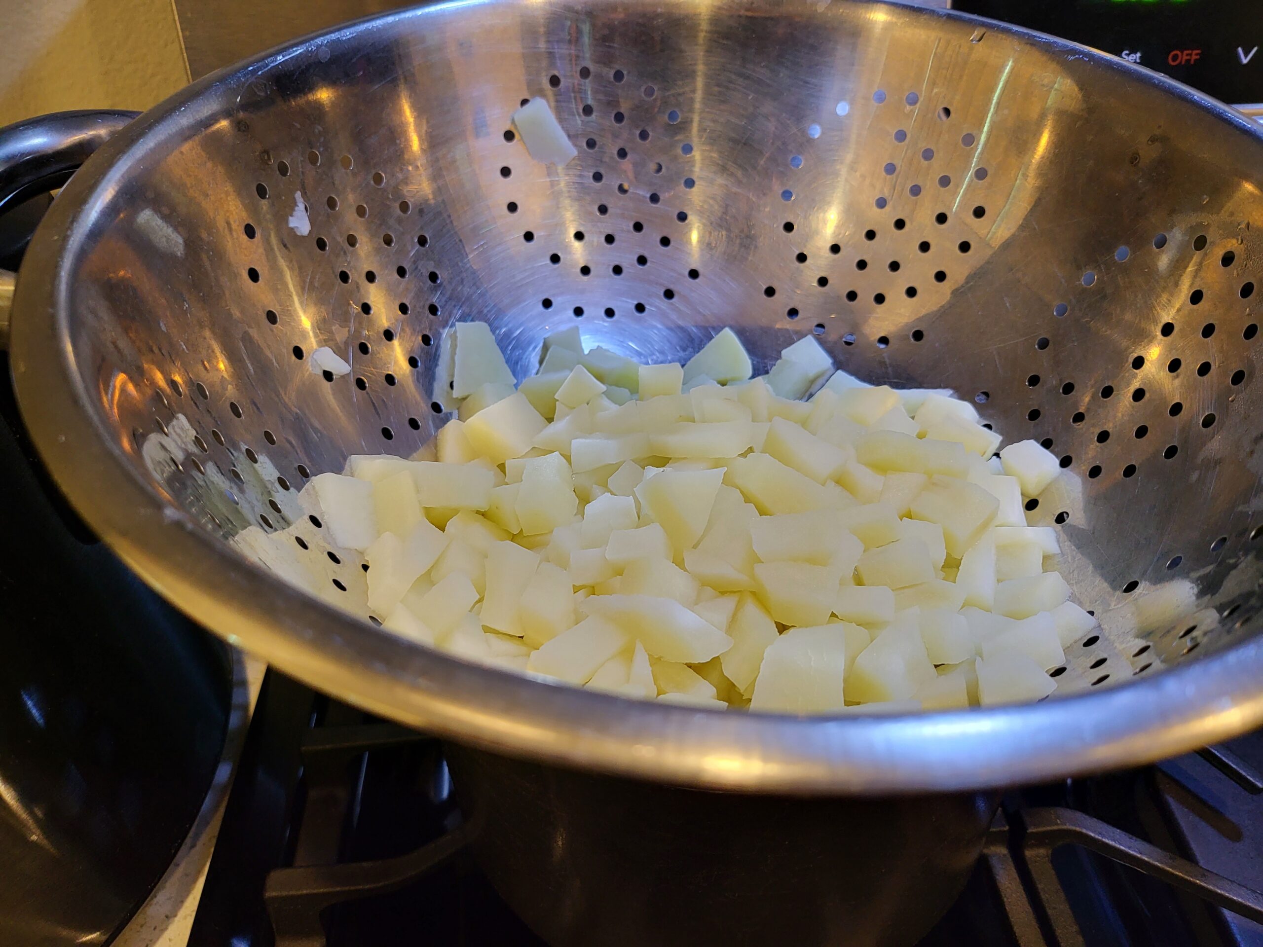 diced cooked potatoes in strainer